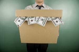 Man holding a box stuffed with cash