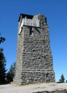 The stone observation tower on top of Moran State Park's Mount Constitution, against a blue sky.