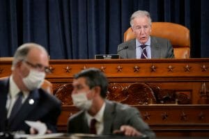 Ways and Means Committee Chair Richard Neal presides over a meeting with two people in masks in the foreground.