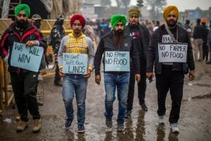 Five men wearing turbans are walking with signs saying "NO FARMER NO FOOD"