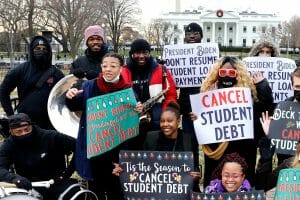 Group of young people in front of the White House holding signs calling for cancellation of student debt.