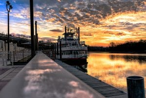 A riverboat with a sunset behind it.