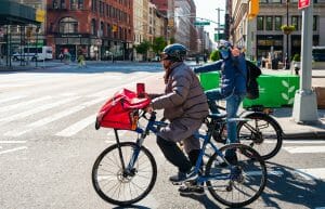 Two people delivering food on bicycles.